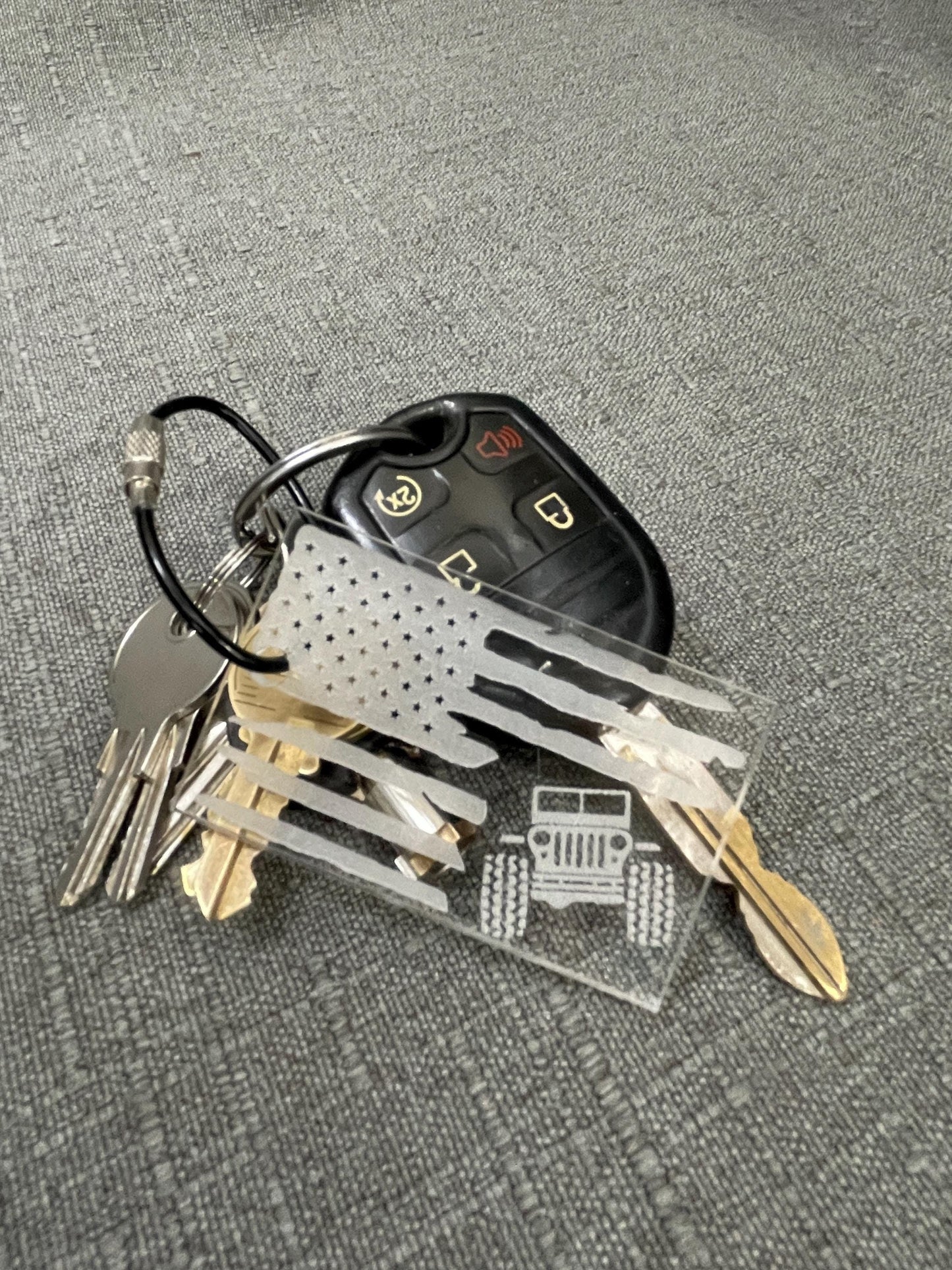 White American Flag key chain with rugged, shredded design and a Jeep silhouette, shown attached to a set of car keys